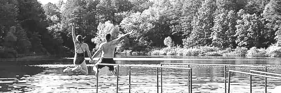 Couple jumping into a lake